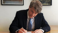 Energy and Clean Growth Minister Chris Skidmore passing the bill into law